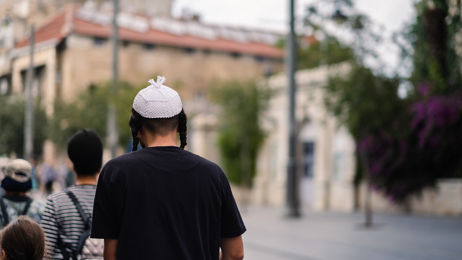 קבוצת אנשים צועדים יחד ברחוב, תחושה של קהילה ושייכות אופיינית לחיי העיר